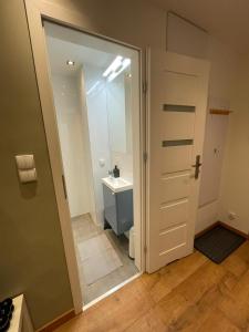 a bathroom with a sink and a toilet and a mirror at Chill Apartament Gdynia in Gdynia