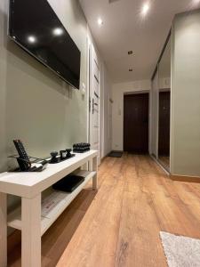 a living room with a table with a tv on the wall at Chill Apartament Gdynia in Gdynia