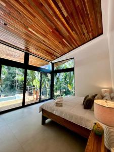 a bedroom with a large bed with a wooden ceiling at Exclusive Rainforest Villas in Tapantí