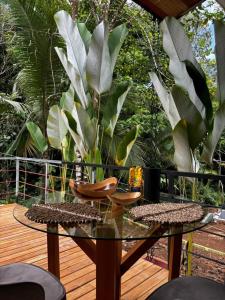 a glass table and chairs on a wooden deck at Exclusive Rainforest Villas in Tapantí