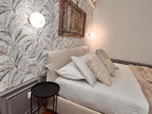 1 dormitorio con cama con almohadas blancas y papel pintado en Compagnia del mare, Cinque terre Full Apt X 2, centro storico,5 minuti dal mare!, en Riomaggiore