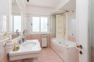 Un baño con lavabo, bañera e inodoro. en Vatican-Metro A Panoramic Penthouse with Jacuzzi, en Roma 56 fotos más