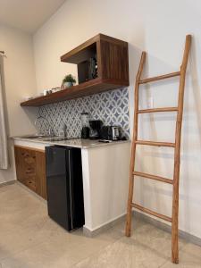 a kitchen with a black refrigerator and a ladder at Santal Tulum Condo Hotel By Marea in Tulum