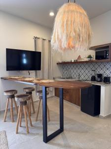 a large wooden table with stools in a kitchen at Santal Tulum Condo Hotel By Marea in Tulum