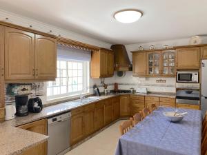 a kitchen with wooden cabinets and a table with a bowl on it at B House Verdizela in Corroios