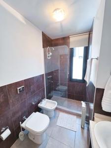 Un baño con inodoro, ducha y lavabo. en Edificio PRISMA I, en Villa Carlos Paz