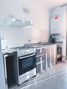 cocina con fogones de acero inoxidable horno superior en Edificio PRISMA I, en Villa Carlos Paz