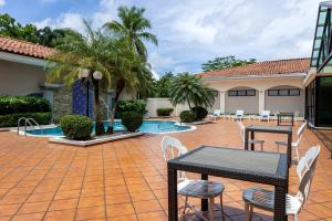 a patio with tables and chairs and a pool at Holiday Inn Panama Canal by IHG in Panama City