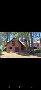 a large brown barn with trees in front of it at Les y Hirondelles in Piriápolis