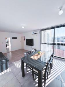 Un comedor con una mesa y sillas en una habitación. en Edificio PRISMA I, en Villa Carlos Paz