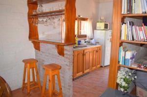 a kitchen with two stools and a kitchen with a fireplace at Les y Hirondelles in Piriápolis +29 photos