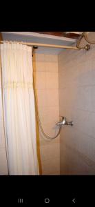 a shower in a bathroom with a shower curtain at Les y Hirondelles in Piriápolis