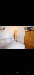 a bedroom with a bed and a wooden cabinet at Les y Hirondelles in Piriápolis