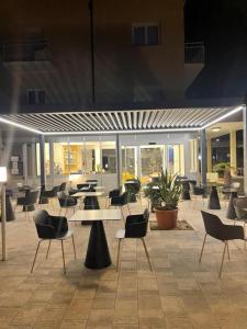 un hall avec des tables et des chaises dans un bâtiment dans l'établissement B&B Mima, à Milano Marittima