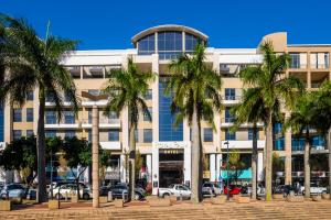 een gebouw met palmbomen ervoor bij Royal Palm Hotel in Durban