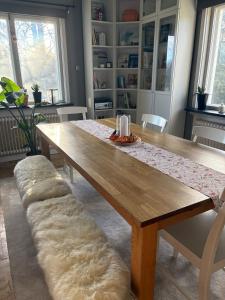 a large wooden table with a bench in a living room at Boreal Cottage in Karungi
