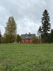 a red house in the middle of a field at Boreal Cottage in Karungi