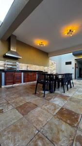 a large kitchen with a table and chairs in it at Chalés da Bica - Modernidade e Aconchego a 100m da Praia in Paracuru +30 photos