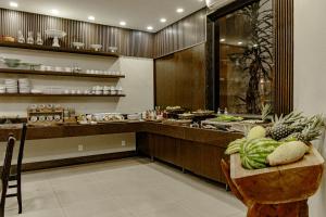 a kitchen with a table with fruits and vegetables on it at Café Palace Hotel in Três Pontas