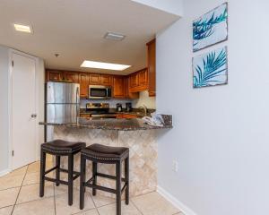 una cucina con 2 sgabelli da bar e un frigorifero di Phoenix VI 6610 condo a Orange Beach
