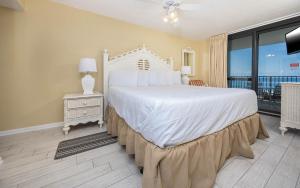 una camera da letto con un grande letto bianco e un balcone di Phoenix VI 6610 condo a Orange Beach