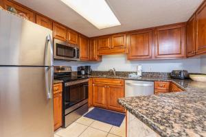 una cucina con armadietti in legno ed elettrodomestici in acciaio inossidabile di Phoenix VI 6610 condo a Orange Beach