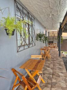 a group of wooden tables and benches against a wall at Hotel El-Shaday in Vila Nova do Sul +26 photos