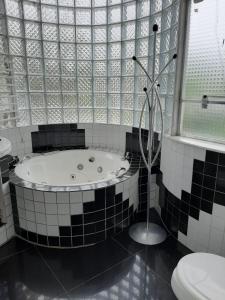 a bathroom with a bath tub and a toilet at ROSA CORTIANA Escalera in São Gabriel