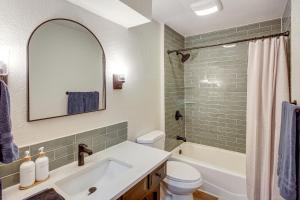 a bathroom with a sink and a toilet and a mirror at 19 Mi to Kansas City Group Retreat with Game Room! in Blue Springs +22 photos