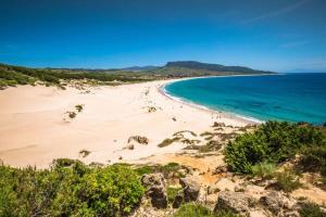 a view of a beach with people in the water at A Beautiful Townhouse with a roof top terrace in Rute