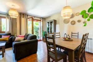 una sala de estar con una mesa y un sofá en Paramita Adosado con Jardin, en Villanúa