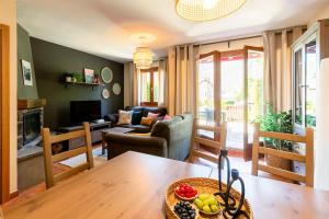 una sala de estar con una mesa y un sofá en Paramita Adosado con Jardin, en Villanúa