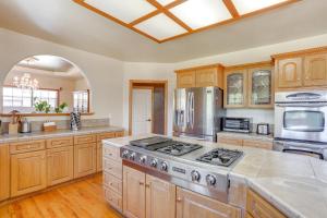 a kitchen with wooden cabinets and a stove top oven at 3 Mi to Sequoia Park Zoo Spacious Home with Sunroom in Rosewood