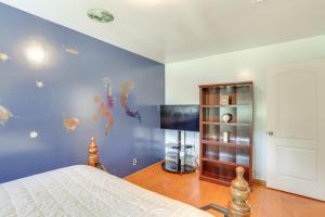 a bedroom with a bed and a blue wall at 3 Mi to Sequoia Park Zoo Spacious Home with Sunroom in Rosewood