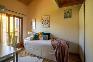 Un dormitorio con una cama con almohadas encima. en Paramita Adosado con Jardin, en Villanúa