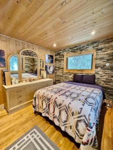 贝菲尔德Hauser's Bayfield Cabin的一间带床和石墙的卧室