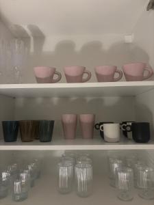a shelf with glasses and cups on it at Cozy apartment in Åmål +17 photos