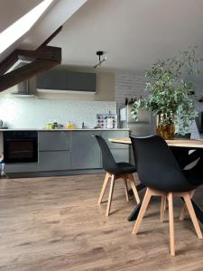 a kitchen with a table and chairs in a kitchen at Le Grenier Chic - T3 duplex - Parking privatif in Saint-Omer