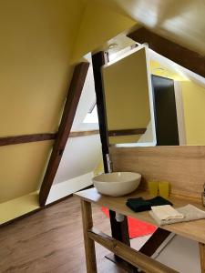 a bathroom with a sink and a mirror on a table at Le Grenier Chic - T3 duplex - Parking privatif in Saint-Omer