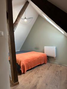 a bedroom with an orange bed in a attic at Le Grenier Chic - T3 duplex - Parking privatif in Saint-Omer