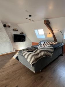 a living room with a couch and a tv at Le Grenier Chic - T3 duplex - Parking privatif in Saint-Omer