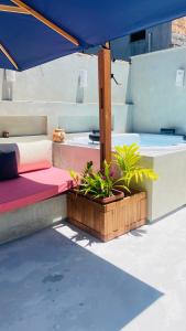 a bed with a blue umbrella and some plants at Casa Rústica com Spa in Arraial d'Ajuda