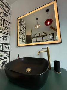 a bathroom with a black sink and a mirror at Ecrin de Charme in Granville +86 photos