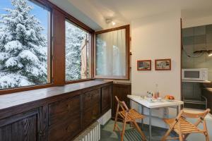 a kitchen with a large window and a table and chairs at Fiori di Miele - Happy Rentals in Bardonecchia