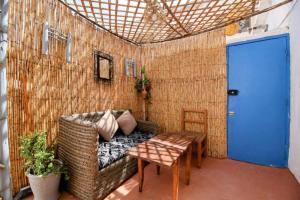 een kamer met een bank, een tafel en een blauwe deur bij Dar janna in Essaouira