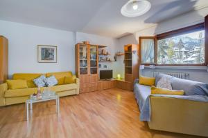 un soggiorno con due divani e una TV di Snow White - Happy Rentals a Bardonecchia Altre 13 foto
