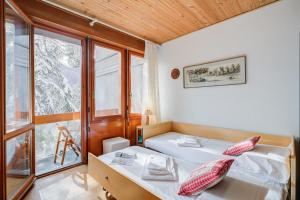 Un dormitorio con dos camas y una ventana. en Slalom 73 - Happy Rentals, en Bardonecchia