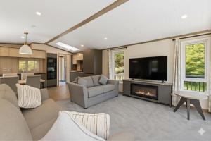 een woonkamer met open haard en tv bij Luxury Lodge 