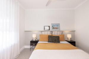 a bedroom with a large bed with two night stands at Koroit Street Cottage in Warrnambool