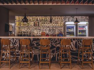 a bar with chairs lined up in front of it at ibis Carlos Barbosa in Carlos Barbosa